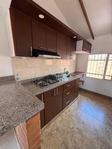 a kitchen with brown cabinets and a counter top at Casa Bonita in Duitama