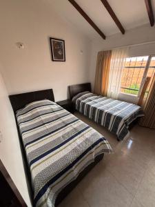 two beds sitting in a room with a window at Casa Bonita in Duitama