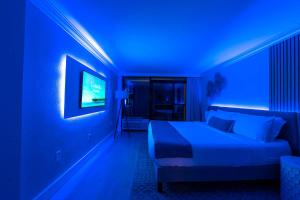 Una habitación azul con una cama y un televisor. en Paradis By Casanita - Oceanfront Lux Designer Suite, en Myrtle Beach