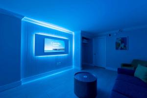 Habitación azul con sofá y TV en Paradis By Casanita - Oceanfront Lux Designer Suite, en Myrtle Beach 26 fotos más