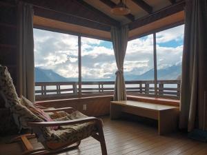 a room with a large window with a view of mountains at Cabaña Celeste - Acceso directo a playa lago Caburgua y cancha de tenis - direct access Beach in Caburgua Lake and tenis court in Pucón