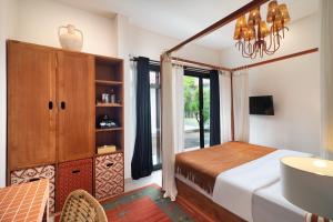 a bedroom with a bed and a dresser and a mirror at Berawa Nest Homes Canggu in Canggu