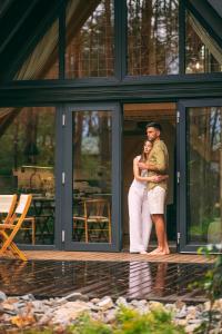 a man and a woman standing on the porch of a house at Bajka Hotel & Resort in Grodziec