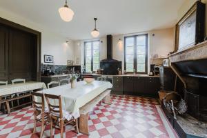 a kitchen with a table and chairs and a piano at Domaine de la Grotte in Sore