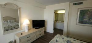 une chambre avec un lit et une télévision sur une commode dans l'établissement Coastal Views Spacious Beachfront Condo, à Daytona Beach