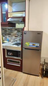 a kitchen with a refrigerator and a stove at Low-key Suites Trees Residences in Manila