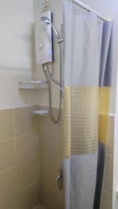 a shower with a shower curtain in a bathroom at Low-key Suites Trees Residences in Manila