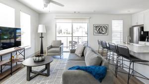 a living room with a couch and a kitchen at Landing at The Gallery - West Huntsville in Huntsville