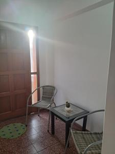 Zimmer mit einem Tisch, Stühlen und einer Tür in der Unterkunft La Casa de María Helenra in Alta Gracia