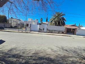 eine leere Straße mit einem Haus und einer Palme in der Unterkunft La Casa de María Helenra in Alta Gracia
