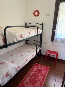 アルツァケーナにあるL'appartamento sul mareのベッドルーム1室(二段ベッド2台、赤いラグ付)