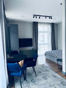 a living room with a table and chairs and a bedroom at Ainių gatvės apartamentai in Panevėžys