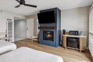 a living room with a fireplace with a tv at 456 Embarcadero Inn & Suites in Morro Bay