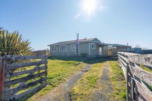 ein Haus mit einem Zaun davor in der Unterkunft The Flax Cottage - National Park Holiday Home in Raurimu Spiral