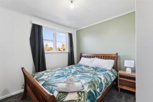 ein kleines Schlafzimmer mit einem Bett und einem Fenster in der Unterkunft The Flax Cottage - National Park Holiday Home in Raurimu Spiral