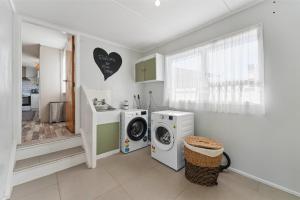 eine Waschküche mit Waschmaschine und Unterlegscheibe in der Unterkunft The Flax Cottage - National Park Holiday Home in Raurimu Spiral