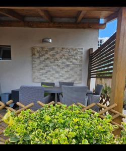 a patio with chairs and a table and some plants at Kids' Paradise House in Balatonboglár