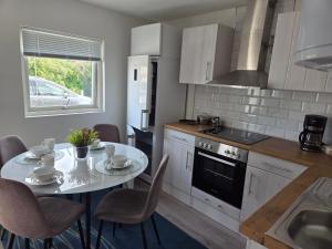 a kitchen with a table and a stove and a sink at Jasmine House in Bromölla