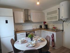 a kitchen with a table and chairs and a white refrigerator at Jasmine House in Bromölla +11 photos