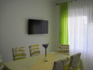 stół jadalny z wazą z kwiatami w obiekcie Apartment in Zadar - Zadar Riviera 7970 w mieście Zadar