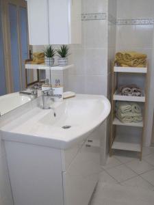 biała łazienka z umywalką i ręcznikami w obiekcie Apartment in Zadar - Zadar Riviera 7970 w mieście Zadar