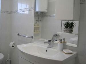 biała łazienka z umywalką i lustrem w obiekcie Apartment in Zadar - Zadar Riviera 7970 w mieście Zadar +26 zdjęć