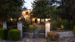a house with a gate in front of a yard at Το Σπίτι της Γιαγιάς in Paralia Rachon