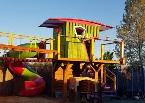 a playground with a slide and a play structure at Kids' Paradise House in Balatonboglár