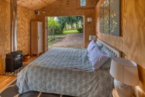 a bedroom with a bed and a door to a yard at Tranquil Woodland Cottage, 10-Min Drive to Clifton in Pill