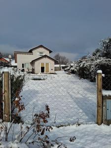 einen schneebedeckten Hof vor einem Haus in der Unterkunft Casita San Martín in San Martín de los Andes