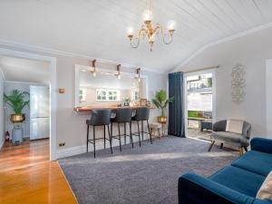 ein Wohnzimmer mit einer Bar und einem blauen Sofa in der Unterkunft Creed Cottage - Whitianga Heritage Retreat in Whitianga