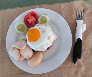a plate of food with an egg and vegetables at Arirang Sea View Homestay in Senggigi