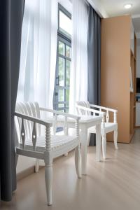two white chairs and a table in front of a window at Vienna Hotel VN in Ho Chi Minh City +23 photos