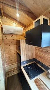 a kitchen with a stove in a tiny house at Nozawa Onsen Tiny Home and Sauna - Mizuho in Iiyama