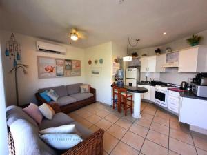 a living room with a couch and a kitchen at Depa con alberca, 10 min caminando playa Ixtapa in Ixtapa