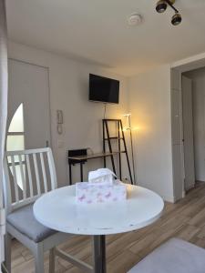 a living room with a white table and chairs at Studio à Bagneux avec terrasse privée, parking et climatisation payants in Bagneux