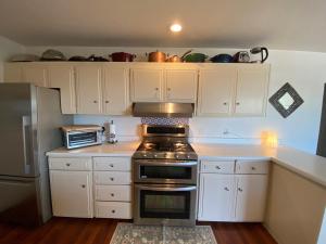a kitchen with white cabinets and a stove top oven at Lavandine Farm in Watsonville
