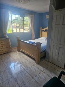 a bedroom with a bed and a window and a door at paradise treasure in Montego Bay