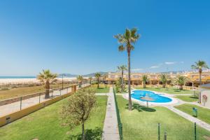 an aerial view of a resort with a swimming pool and palm trees at Apartamento Tortuga I in Tarifa