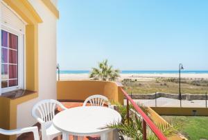 balcón con mesa y sillas y la playa en Apartamento Tortuga I, en Tarifa