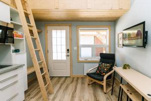 a room with a desk and a ladder and a chair at Adventure Knap Shack in Nordegg