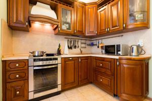 a kitchen with wooden cabinets and a stove top oven at Star Apartment On Kyievskaya in Moscow