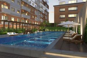 a swimming pool with chairs and an umbrella next to a building at Petapolis apartment in Guatemala