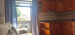 a kitchen with a window with a view of a balcony at Frente a la Plaza del Charco - Mar y vida desde tus 2 balcones in Puerto de la Cruz