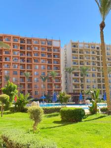 a resort with palm trees and a large building at Amazing view apartment in Golf Porto Marina in El Alamein