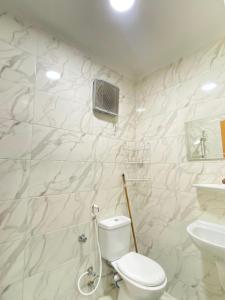 a white bathroom with a toilet and a sink at Amazing view apartment in Golf Porto Marina in El Alamein