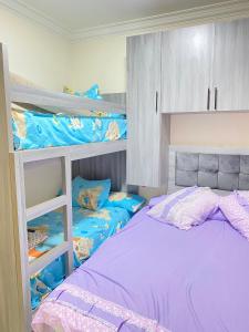 a bedroom with two bunk beds with purple sheets at Amazing view apartment in Golf Porto Marina in El Alamein +18 photos
