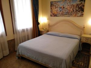A bed or beds in a room at Hotel Ca' Formenta