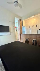 Una cocina con una mesa y taburetes en una habitación. en Suíte 300 Pitangueiras - na quadra da praia, en Guarujá