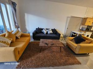 ein Wohnzimmer mit zwei Sofas und einem Couchtisch in der Unterkunft Amwaj sidi abed el rahman in Banī Ghālib